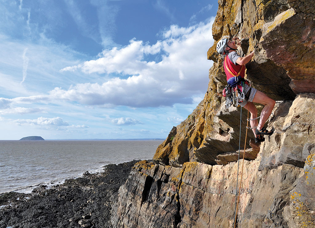 Rick Sewards psyching up for the crux roof on In The Soup (E1 5b) with the island of Steep Holm in the background. Photo: © Mark Davies